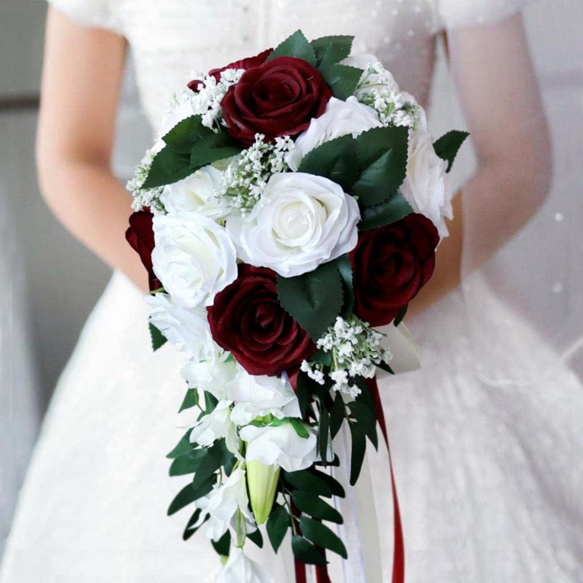 bouquet-de-mariee-artificiel-en-cascade-avec-des-roses-blanches-et-des-touches-de-gypsophile-tenu-par-une-mariee-rouge